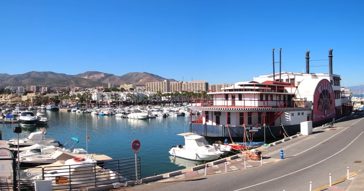 Yachts and boats moored at Puerto Marina, Benalmádena Costa, with the resort skyline and mountains behind — Benalmádena yacht party escorts guide 2026