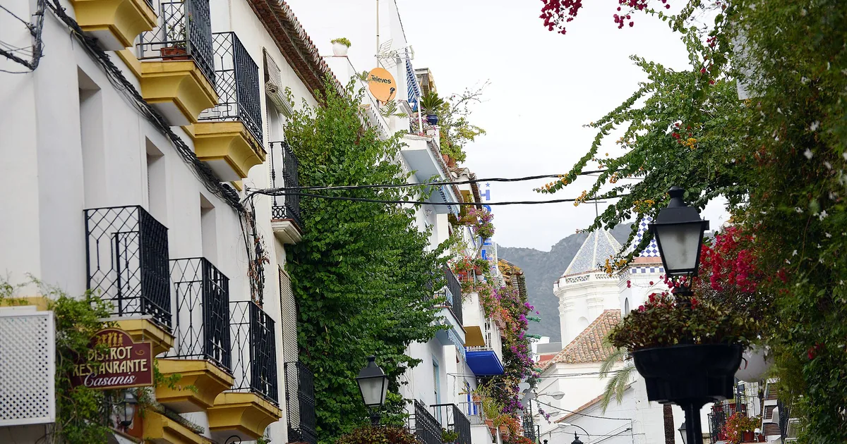 Narrow old-town street in Marbella with bougainvillea and wrought-iron balconies — boutique hotels guide