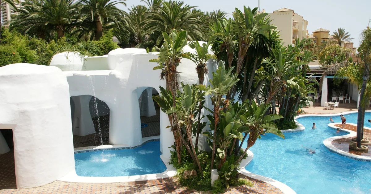 Pools and whitewashed grotto architecture among palms at the Don Carlos resort in East Marbella — five-star hotels review