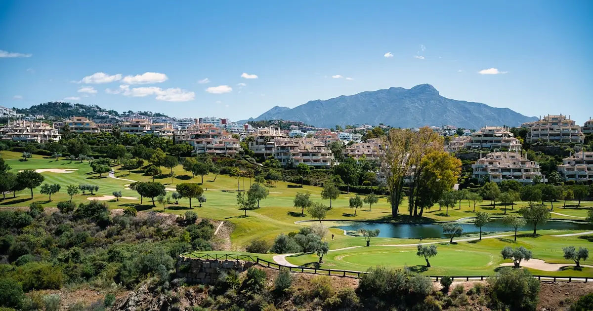 Aerial view of a gated luxury villa estate above Benahavís with golf fairways and mountains — La Zagaleta escort villa booking guide 2026