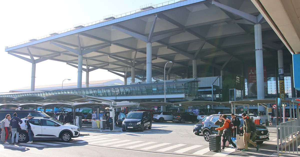 Cars and passengers at the arrivals forecourt of Málaga-Costa del Sol Airport — transfers to Marbella