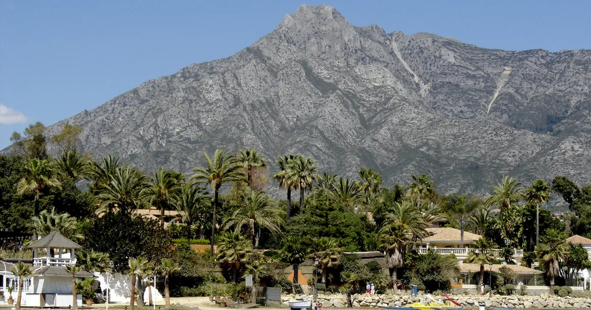 Puente Romano's palm-lined beachfront on the Golden Mile with La Concha mountain behind, Marbella