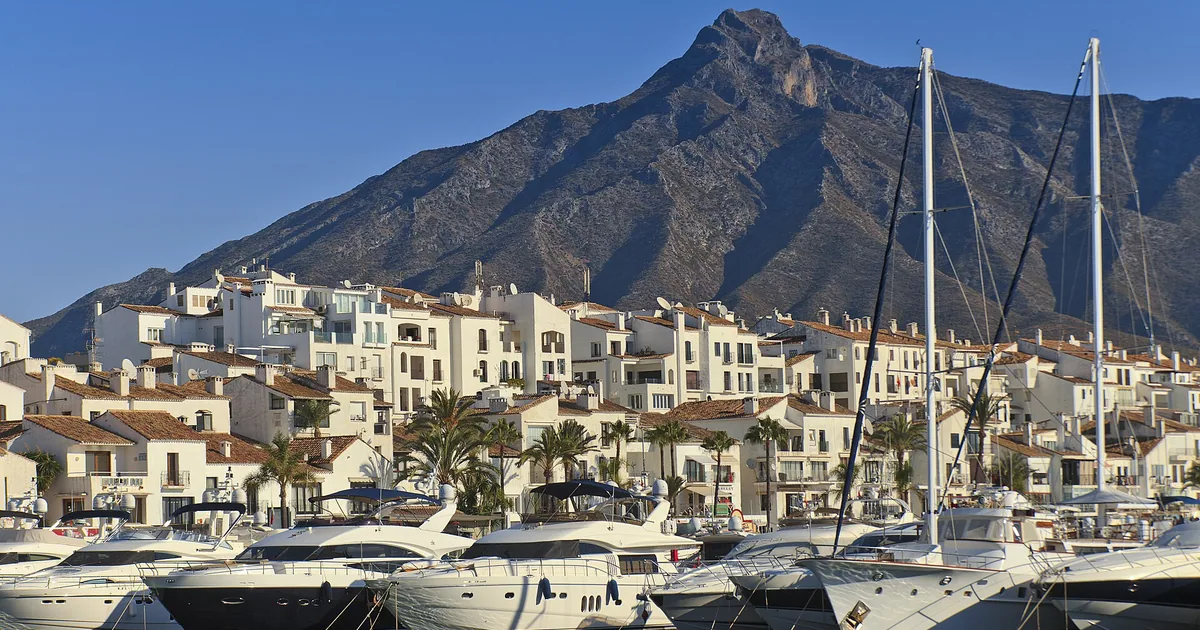 Sailing yachts and motor yachts moored in Puerto Banús below La Concha mountain — regatta season guide