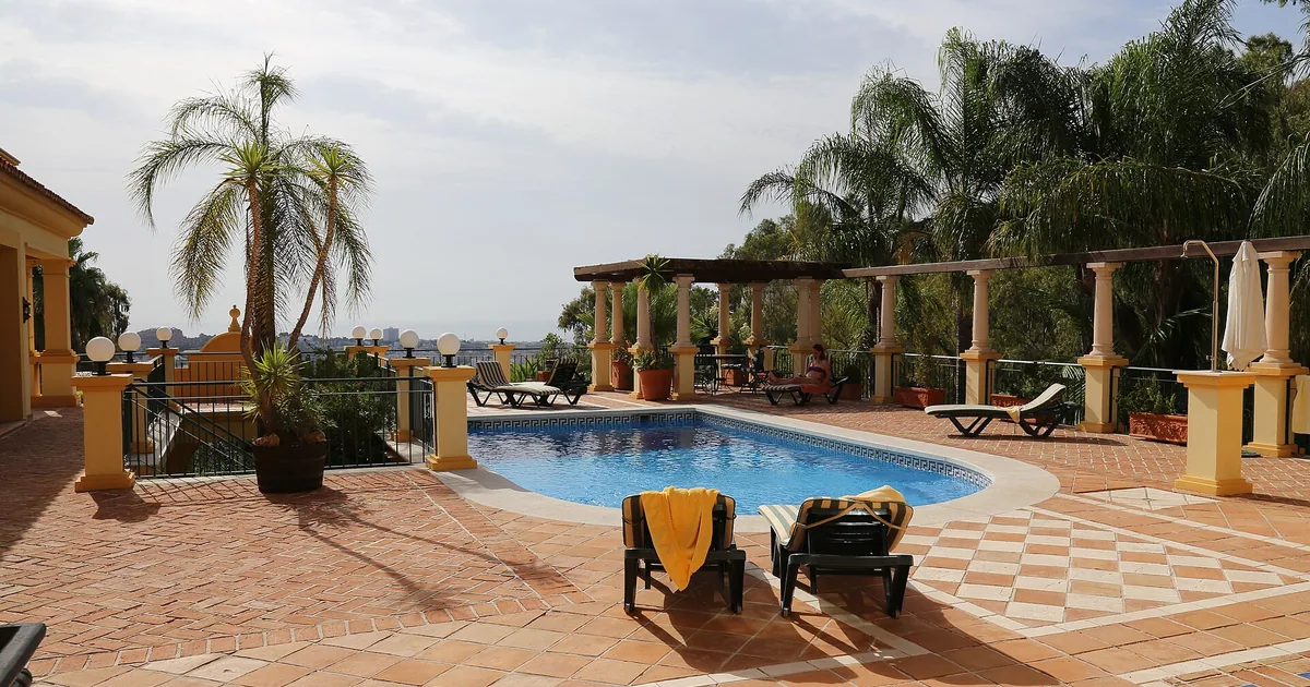 Pool terrace and sunbeds at a private villa in Marbella with views to the coast — villa rentals guide