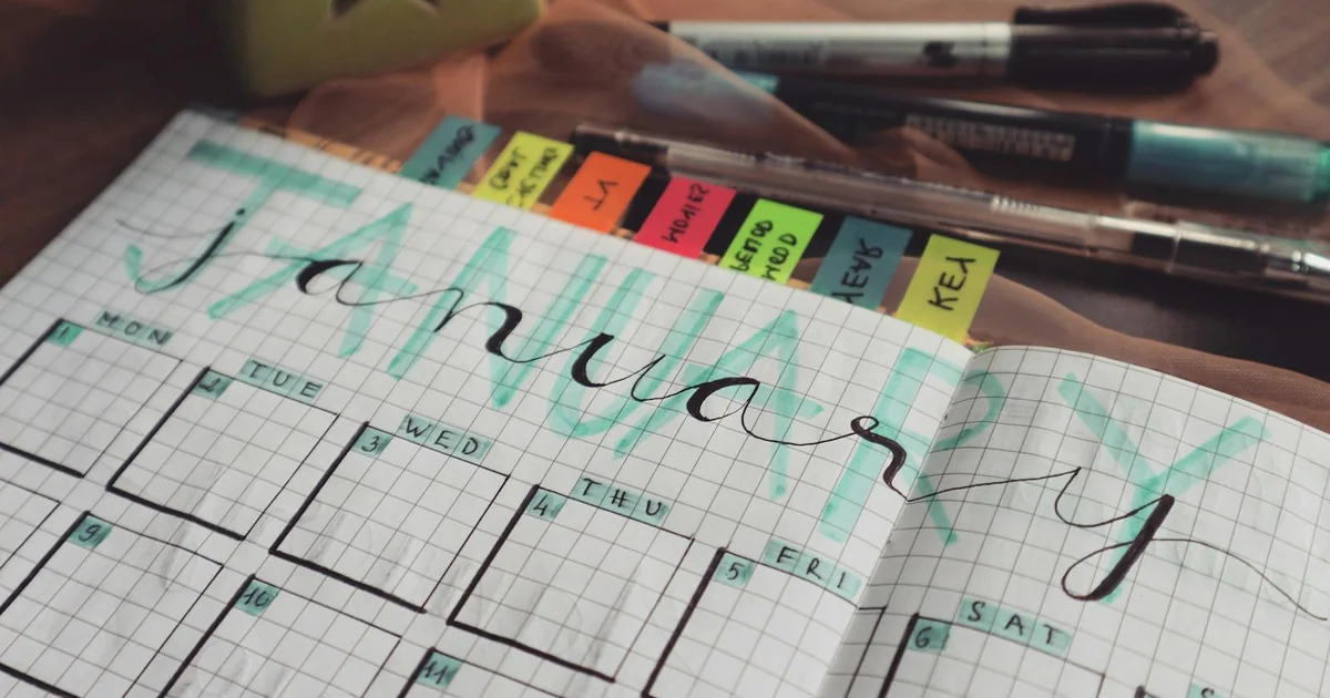 Open weekly planner beside hotel suite key cards — Marbella escort weekend vs weekday price comparison 2026